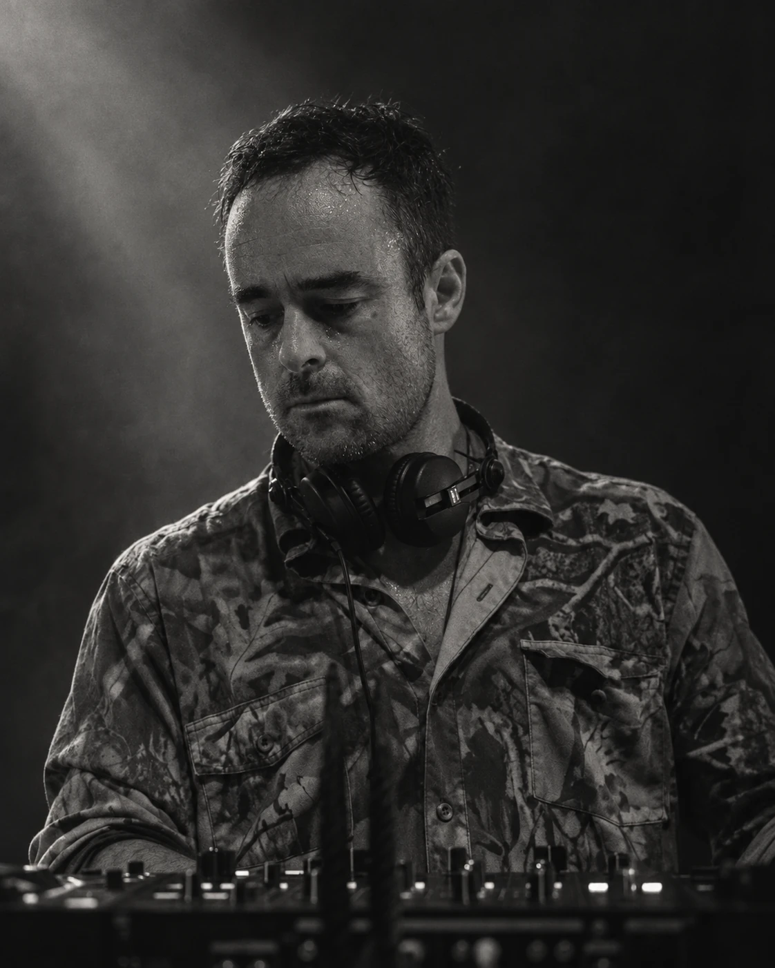 Manymen performing a DJ set, with headphones around his neck